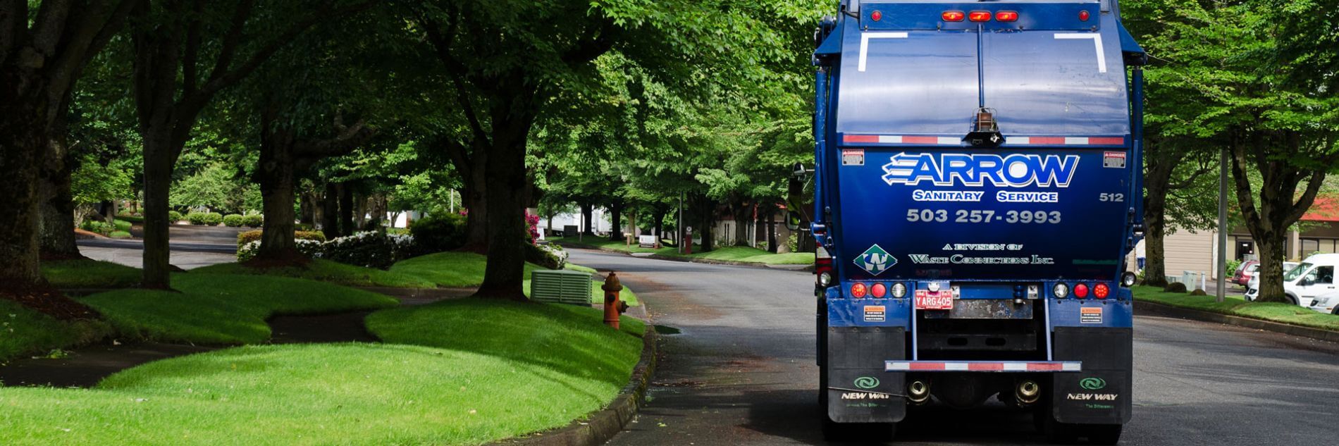 Photo of Arrow Sanitary Service truck driving through residential neighborhood.